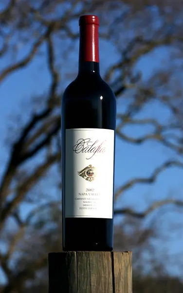 A bottle of Calafia Napa Valley Cabernet Sauvignon on a vineyard post against the sky